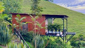 ein kleines Haus mit einem Grasdach und einer Veranda in der Unterkunft Glamping Ocaso in Llanitos