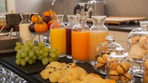 a table with three bottles of orange juice and fruit at Good Morning Bologna in Bologna