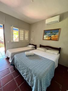 two beds in a hotel room with two bedsvisor at Pousada e Restaurante do Francisco in Icapuí