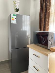 a stainless steel refrigerator in a kitchen with a microwave at The Plum in Louis Trichardt