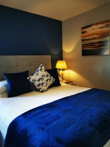 a bedroom with a large bed with a blue comforter at Ocean Heights B&B in Lissadell