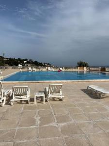 a group of lounge chairs and a swimming pool at Appartement en résidence vue sur mer in Roquebrune-sur-Argens