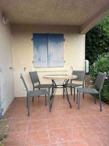 a table and chairs sitting on a patio at Appartement en résidence vue sur mer in Roquebrune-sur-Argens