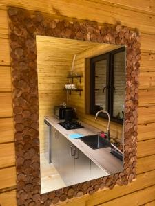 a mirror on the wall of a kitchen in a log cabin at Sunny Side Cottage in Stepantsminda
