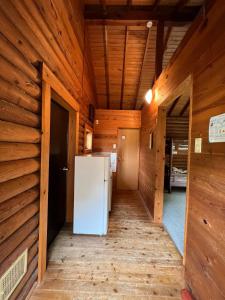 Nasu Takahara Auto Campsite - Vacation STAY 42065v في ناسوشيوبارا: ثلاجة بيضاء في غرفة بجدران خشبية