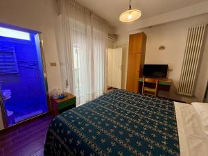 una camera con letto, finestra e televisore di Hotel Iride Suite & Breakfast- ideale per famiglie e coppie a Riccione