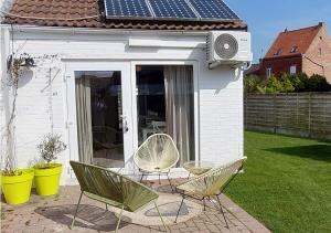 two chairs and a table in front of a house at Salty - Vakantiehuisje op de grens van Bredene-De Haan in Bredene