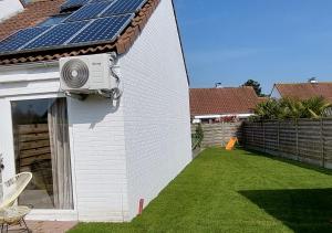 una casa con un panel solar a un lado. en Salty - Vakantiehuisje op de grens van Bredene-De Haan en Bredene