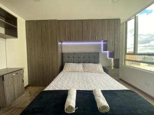 a bedroom with a bed with two towels on it at Bogotá Ejecutiva, Torre Acqua centro in Bogotá