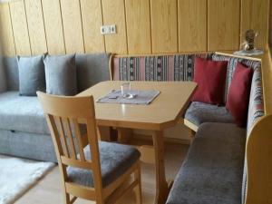 东蒂罗尔地区马特赖Ferienwohnung in der ersten Etage mit maßgefertigter Möblierung的一张带两把椅子的木桌和一张沙发