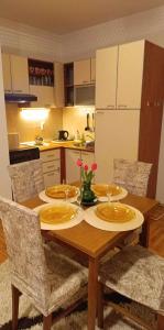 un tavolo da pranzo con sedie e una cucina di DORA Apartman a Palić
