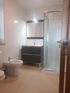 uma casa de banho com um chuveiro, um WC e um lavatório. em Casa do Viso em Oliveira do Hospital