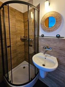 a bathroom with a glass shower and a sink at Szum i Las in Szklarska Poręba