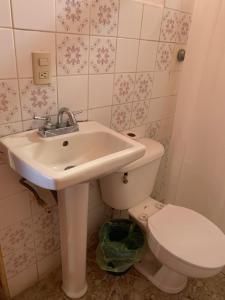 a bathroom with a sink and a toilet at Hotel Aurora in Flores