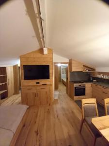 una gran sala de estar con muebles de madera y TV de pantalla plana. en Bauernhof Auhof, en Wagrain