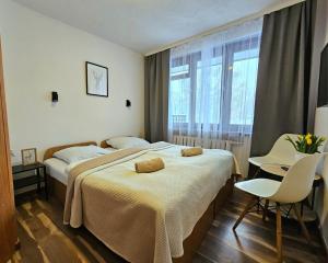 a hotel room with two beds and a table and chairs at Szum i Las in Szklarska Poręba