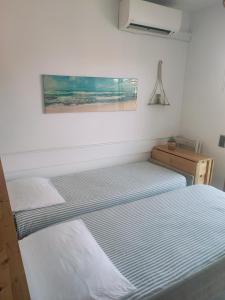 two beds in a bedroom with a painting on the wall at Apartamento frente al mar in Cambrils +12 photos