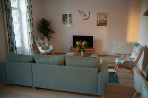 sala de estar con sofá y mesa en Le charmant cocon, en La Bourboule