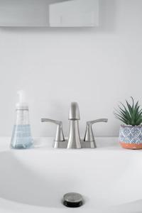 a bathroom sink with two faucets and a plant at Spacious Home Close to Downtown Long Beach & Convention Ctr in Long Beach