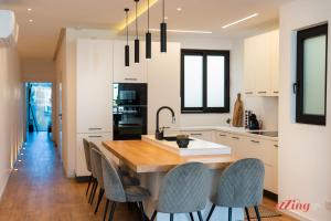 uma cozinha com uma grande mesa de madeira e cadeiras em A Stylishly Dreamy Gozo Apartment em Marsalforn