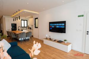 uma sala de estar com um sofá e uma sala de jantar em A Stylishly Dreamy Gozo Apartment em Marsalforn