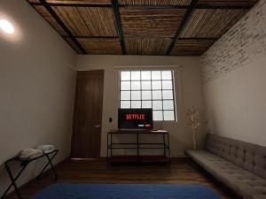 a living room with a tv on a table and a window at Pepe's House Usaquén I Cozy Hotel in Bogotá +31 photos