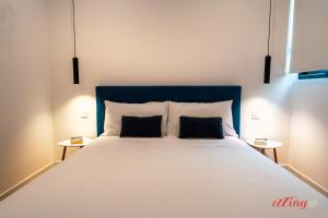 um quarto com uma cama grande e 2 almofadas em A Stylishly Dreamy Gozo Apartment em Marsalforn