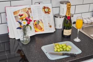 una mesa con un plato de uvas y una botella de vino en Perfect for Professionals in LS1 & LGI - Private Garden! Contact us for Better Offers! en Leeds