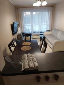 uma sala de estar com uma mesa e um sofá em Apartament em Legionowo