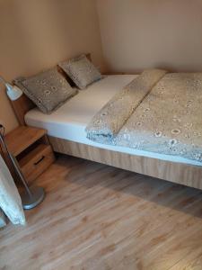 a small bedroom with a bed and a wooden floor at Apartament in Legionowo