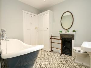 een badkamer met een bad, een wastafel en een spiegel bij Beckhythe Cottage in Cromer +67 foto's