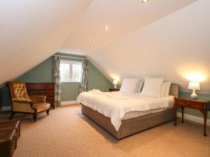 een slaapkamer met een groot bed en een stoel bij Beckhythe Cottage in Cromer