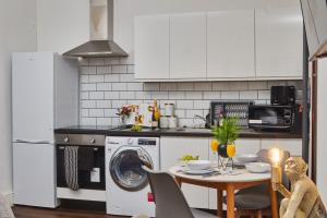 a kitchen with a washing machine and a table at Perfect for Professionals in LS1 & LGI - Private Garden! Contact us for Better Offers! in Leeds