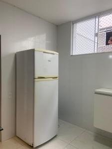 a white refrigerator in a room with a window at Apartamento à 3 minutinhos da praia do forte in Cabo Frio