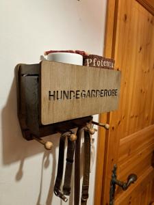 un televisor en una pared con una taza en él en Ferienwohnung im Heidjerhaus, en Suderburg