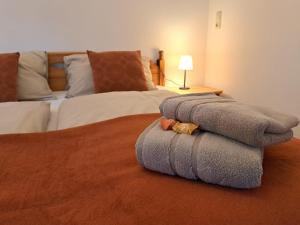 un montón de toallas en una cama en un dormitorio en Ferienwohnung im Heidjerhaus, en Suderburg