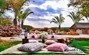 a picnic table with pillows on top of a field at Grand Bay Botanical Gardens & Resort 