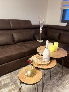 two tables with a wine glass and a wine bottle at Lux apartment Sky Central Residence Zlatibor in Zlatibor