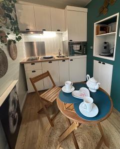 una pequeña cocina con mesa y sillas en una habitación en The Tiny home avec jacuzzi 5 min du lac du Bourget 10 min d Aix les bains et Chambery, en Voglans