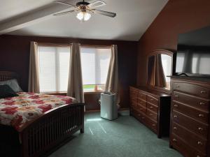 1 dormitorio con 1 cama y ventilador de techo en Luxury 3-Bedroom home, en Caribou