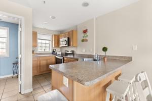 a kitchen with a counter top and chairs in it at Beachview OC 2 Ocean Block in Ocean City