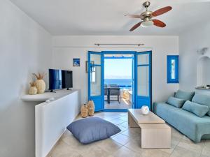 een woonkamer met een blauwe bank en een tv bij Paros Luxury Villa 2mins from the beach in Piso Livadi