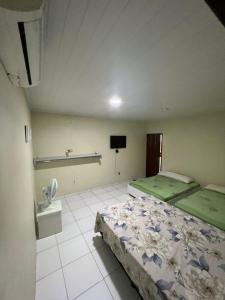 ein Schlafzimmer mit einem Bett und einem TV. in der Unterkunft Lar da paz - Ilha da Crôa in Barra de Santo Antônio