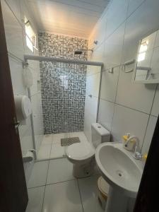 uma casa de banho com um chuveiro, um WC e um lavatório. em Lar da paz - Ilha da Crôa em Barra de Santo Antônio