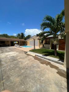 a house with a palm tree and a driveway at Lar da paz - Ilha da Crôa in Barra de Santo Antônio