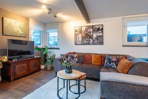 un soggiorno con divano e TV di Watervillashiraz ad Aalsmeer