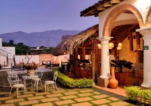 a patio with chairs and a table and a building at Hotel Santa Barbara Colonial - Santa Fe de Antioquia in Santa Fe de Antioquia