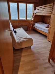 a bedroom with two bunk beds and a ladder at Appartement au pied des télécabines in La Tzoumaz