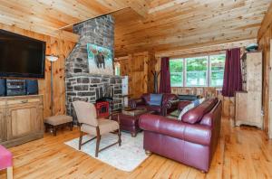 sala de estar con sofá y chimenea de piedra en The Lakehouse, en Carnarvon
