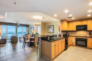 a kitchen with wooden cabinets and a dining room at 1 Portofino 1005 at Pensacola Beach in Pensacola Beach